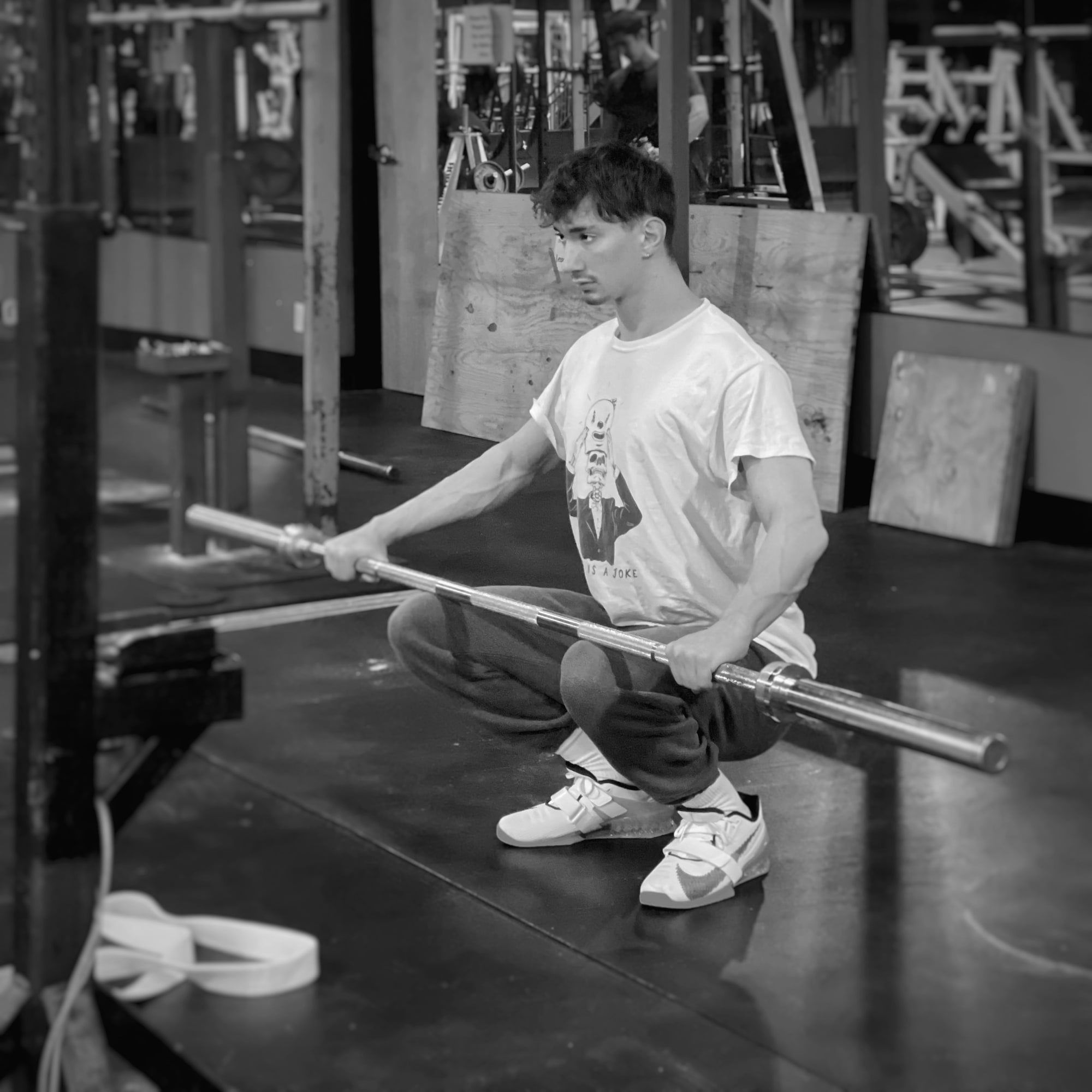 Approved press photograph of Andrew Valentine seated with a barbell in a commercial gym.