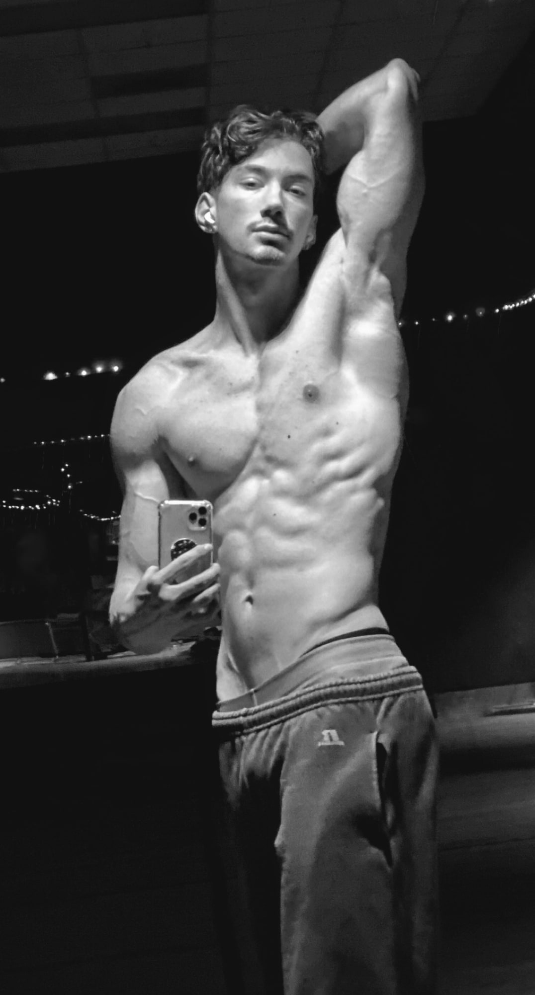Andrew Valentine photographed at night, city lights behind him.